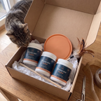 Paket mit 3 Dosen, Leckmatte und Federangel wird ausgepackt